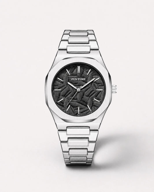 Luxora Obsceren premium herenhorloge met zilveren metalen band, zwarte reliëfwijzerplaat en krachtig minimalistisch design.