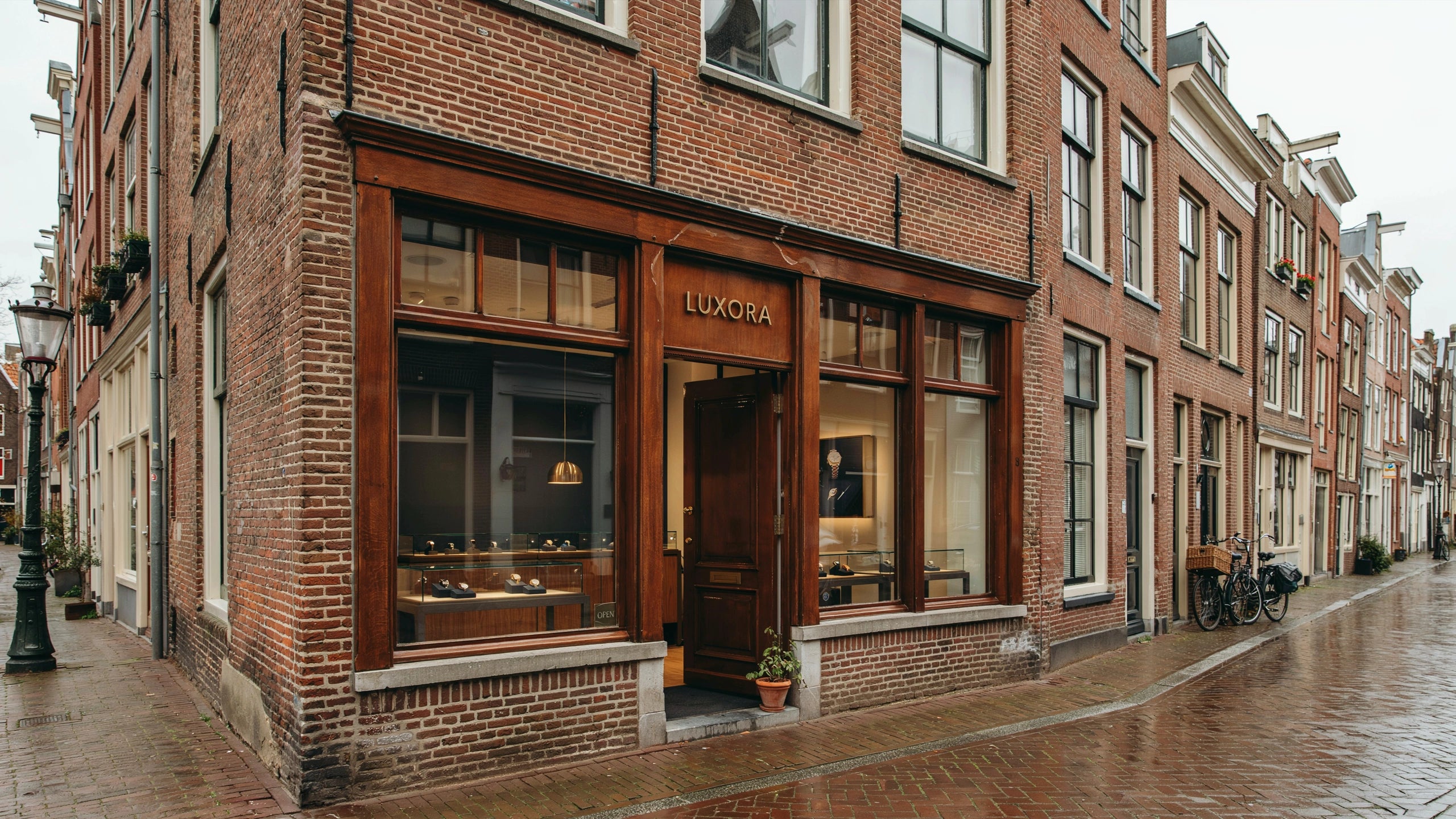 Luxora horlogeboetiek in Nederland met luxe etalage, bakstenen gevel en elegante Nederlandse winkelstraat.